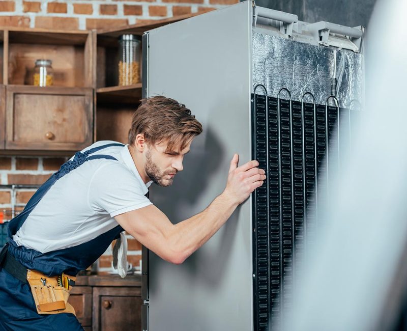 young-repairman-in-protective-workwear-moving-refr-resize.jpg repair